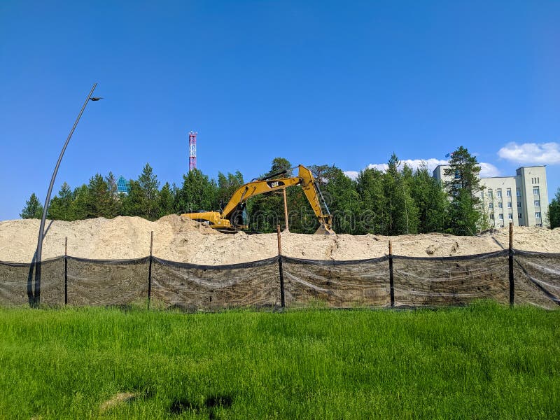Noyabrsk russia 21 giugno 2022 : escavatore per gattini per spianare una grande pila di sabbia per preparare una nuova strada immagini stock libere da diritti