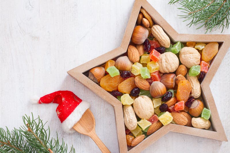 Christmas nuts and dried fruit mix in star-shaped bowl on white background assortment of delicacies concept. Christmas nuts and dried fruit mix in star-shaped bowl on white background assortment of delicacies concept