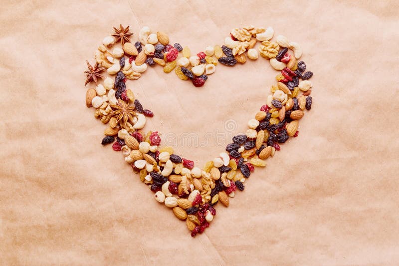 Aesthetic heart shaped mixed nuts from above. Healthy food and snacks. Walnuts, almonds, hazelnuts and cashews. Raisins and cranberries. Aesthetic heart shaped mixed nuts from above. Healthy food and snacks. Walnuts, almonds, hazelnuts and cashews. Raisins and cranberries.