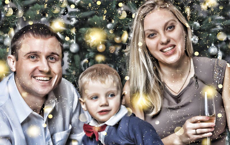 Noël de nouvelle année La jeune famille heureuse avec un petit fils souriant heureusement rencontre la nouvelle année à la maison image stock Noël de nouvelle année La jeune famille heureuse avec un petit fils souriant heureusement rencontre la nouvelle année à la maison image stock