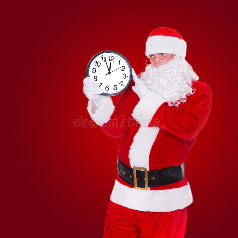 Noël Santa Claus indiquant à l'horloge montrant cinq minutes le minuit photo stock Noël Santa Claus indiquant à l'horloge montrant cinq minutes le minuit photo stock