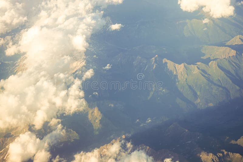 Nuages au-dessus des montagnes autrichiennes plaquées des Alpes de neige vues d'une fenêtre d'avion photographie stock