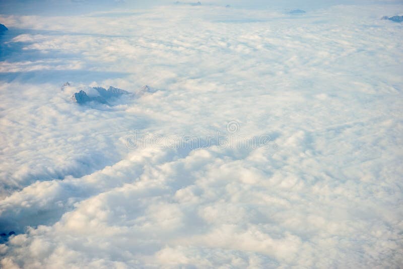 Nuages au-dessus des montagnes autrichiennes plaquées des Alpes de neige vues d'une fenêtre d'avion images libres de droits
