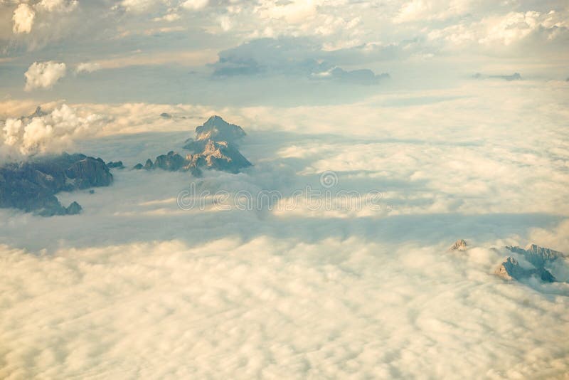 Nuages au-dessus des montagnes autrichiennes plaquées des Alpes de neige vues d'une fenêtre d'avion image stock