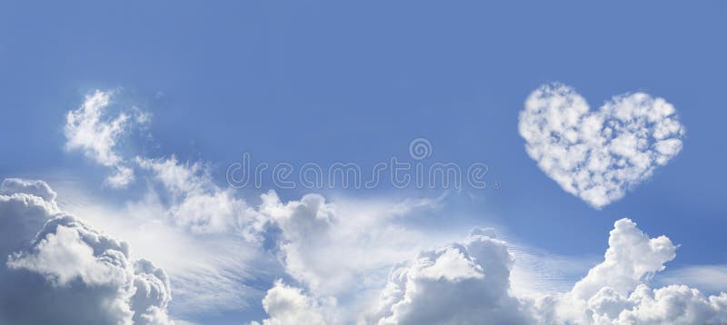 Wide Blue Sky Background with various fluffy clouds and one large Love Heart Shaped cloud formation on right hand side. Wide Blue Sky Background with various fluffy clouds and one large Love Heart Shaped cloud formation on right hand side