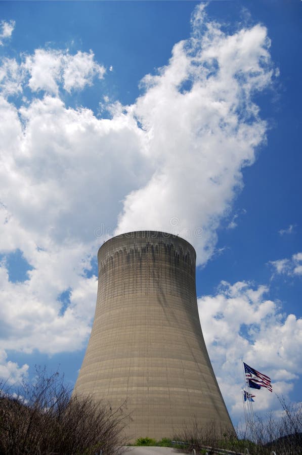 Jaderné chladicí věž s Americkou vlajkou vedle ní.