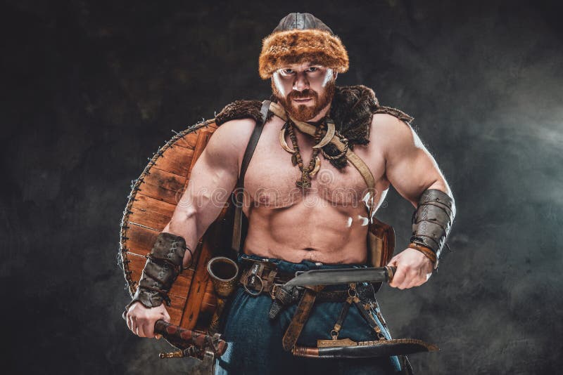 Nude and muscular viking with armed with hatchet and knife