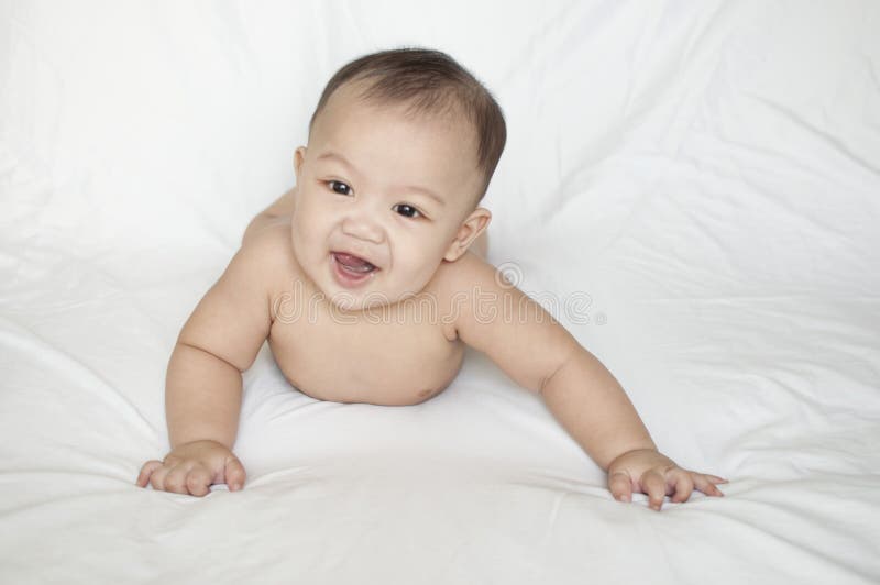 A nude portrait of a smiling baby boy indoor. A nude portrait of a smiling baby boy againts white background stock photos A nude portrait of a smiling baby boy indoor. A nude portrait of a smiling baby boy againts white background stock photos