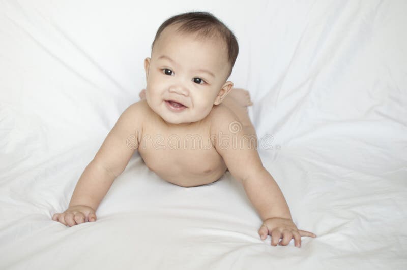 A nude portrait of a smiling baby boy indoor. A nude portrait of a smiling baby boy againts white background stock photography A nude portrait of a smiling baby boy indoor. A nude portrait of a smiling baby boy againts white background stock photography