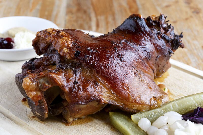 Nudillo tradicional del cerdo de carne asada en el tablero de madera con las salmueras imagen de archivo libre de regalías