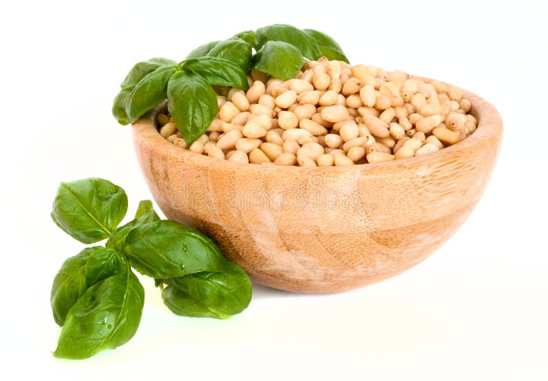 Nueces de pino en un cuenco con albahaca fresca: ingredientes para la salsa del pesto fotografía de archivo libre de regalías Nueces de pino en un cuenco con albahaca fresca: ingredientes para la salsa del pesto fotografía de archivo libre de regalías