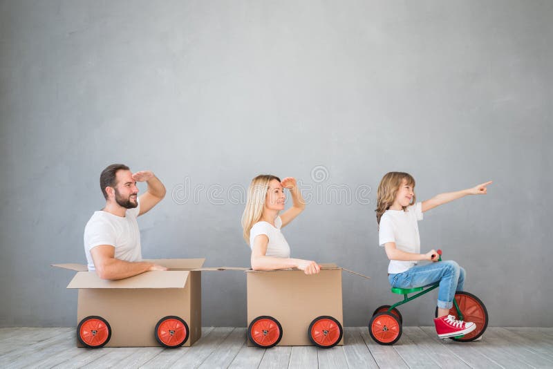 Happy family playing into new home. Father, mother and child having fun together. Moving house day and express delivery concept. Happy family playing into new home. Father, mother and child having fun together. Moving house day and express delivery concept
