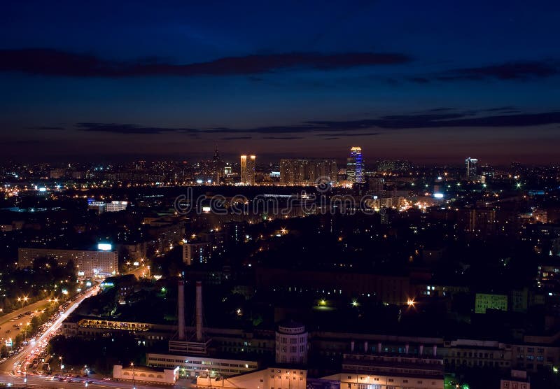 Modern contemporary Russian architecture cityscape: aerial view from above of night megalopolis / city Moscow (Russia) at night / evening with buildings, alight street, streetlights, traffic, sky and clouds. Modern contemporary Russian architecture cityscape: aerial view from above of night megalopolis / city Moscow (Russia) at night / evening with buildings, alight street, streetlights, traffic, sky and clouds