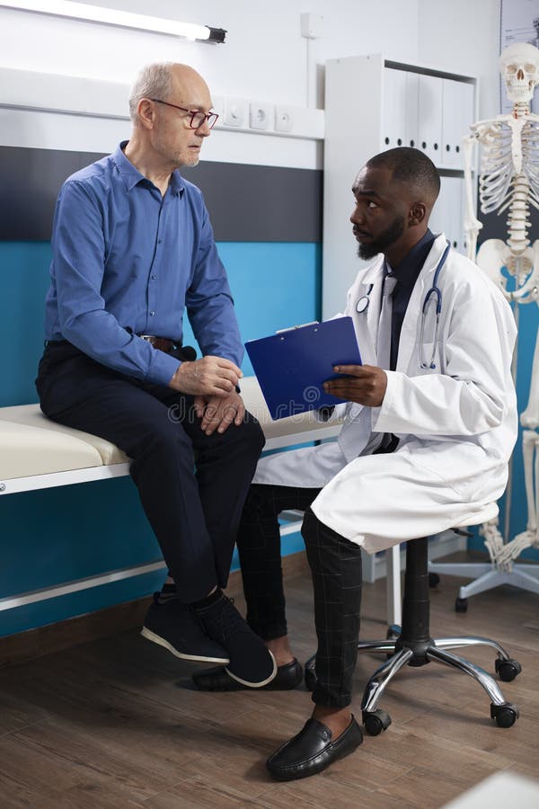 Pensionar ascultând un doctor negru royalty free stock photo