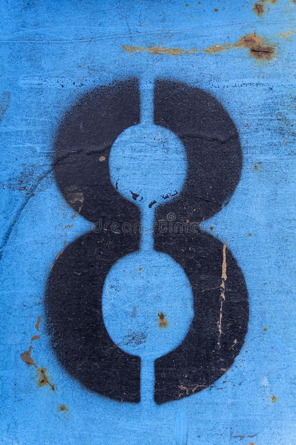 Number 8 in black paint on an old blue iron surface with rust texture and traces of dirt.