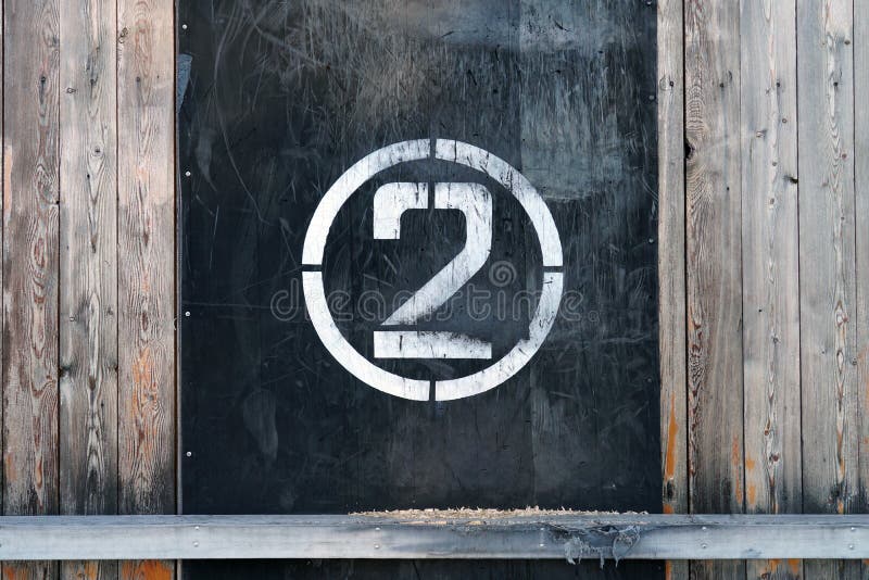 Number 2 in circle, on old rubber banner on stadium wall. White winner stamp with scratches on black background stock photography