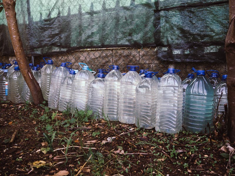 Number of Plastic Bottles Near the Wall in the Garden Stock Photo