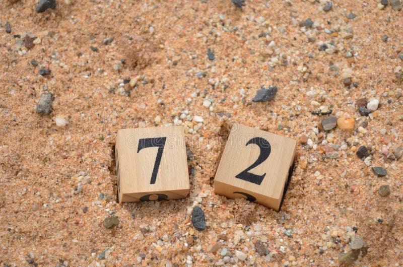 Number 72, rating, award, Cover design in natural concept with a number cube on a sand background.