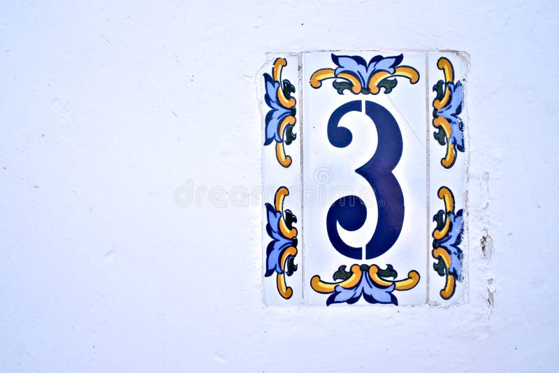 Number 3, three, decorative Spanish tiles on a white wall.