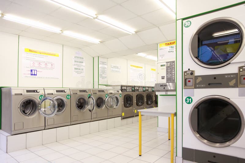 Number of washing machines in empty public laundry stock images