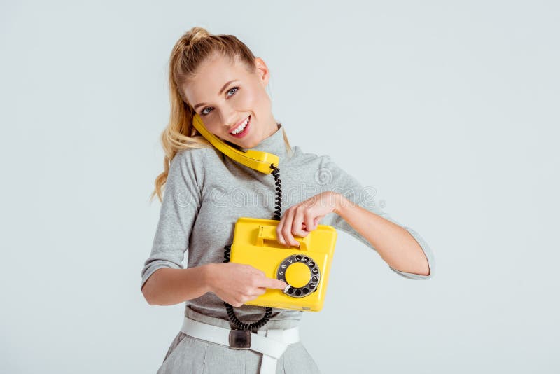 numero di telefono di composizione della donna sul telefono giallo d'annata isolato fotografia stock libera da diritti numero di telefono di composizione della donna sul telefono giallo d'annata isolato fotografia stock libera da diritti