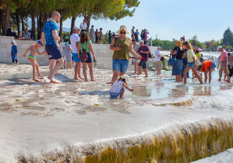 Numerosi turisti camminano in una giornata di sole su una travertina unica immagine stock libera da diritti