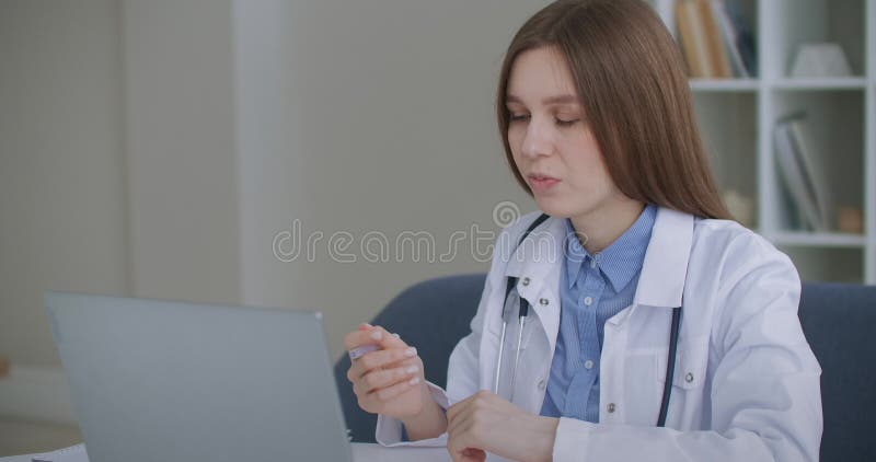 Numirea online cu o femeie cu experiență în medicina muncii comunică online cu pacientul sau colega stock video footage