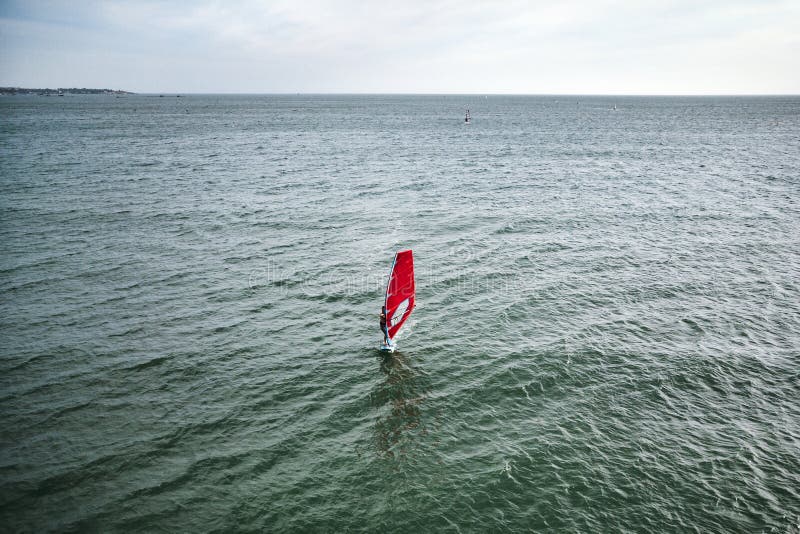 nuotate estreme dell'atleta dell'uomo sulla spuma del vento sull'onda del mare contro il mare blu e l'orizzonte Sport acquatici e immagine stock nuotate estreme dell'atleta dell'uomo sulla spuma del vento sull'onda del mare contro il mare blu e l'orizzonte Sport acquatici e immagine stock