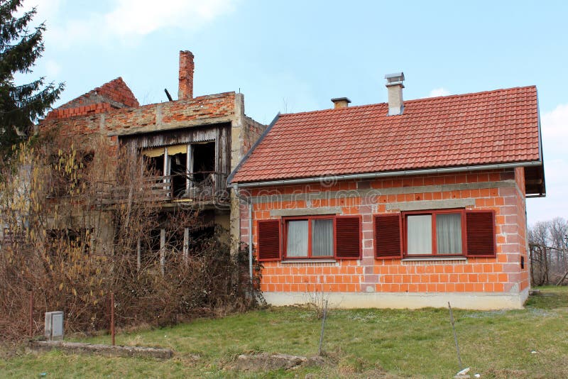 Nuova casa suburbana non finita accanto alla vecchia casa rovinata immagini stock libere da diritti Nuova casa suburbana non finita accanto alla vecchia casa rovinata immagini stock libere da diritti