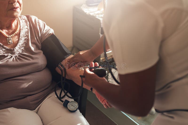 Nurse examining the blood pressure of a senior patient