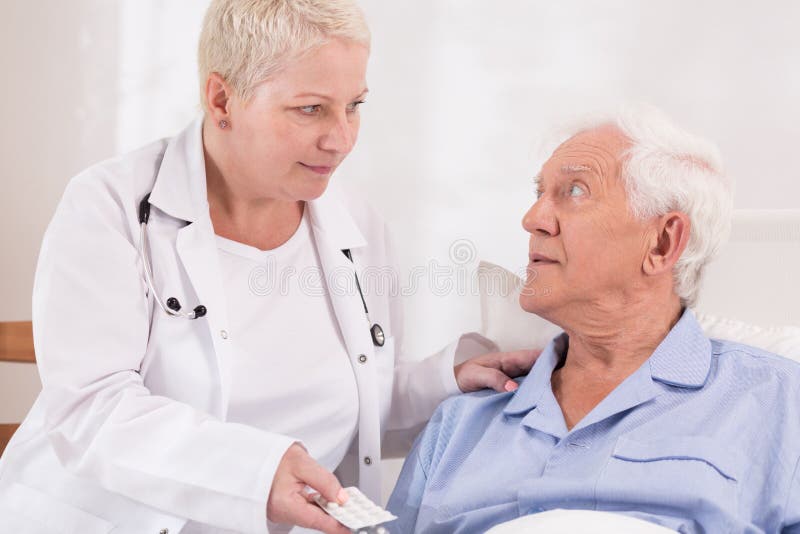 Nurse giving pills to senior patient stock photo Nurse giving pills to senior patient stock photo