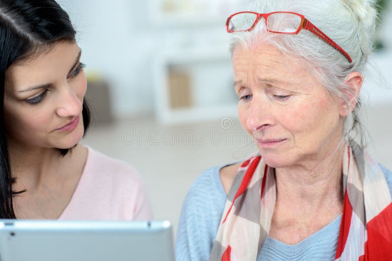 Nurse helping old woman managing daily tasks