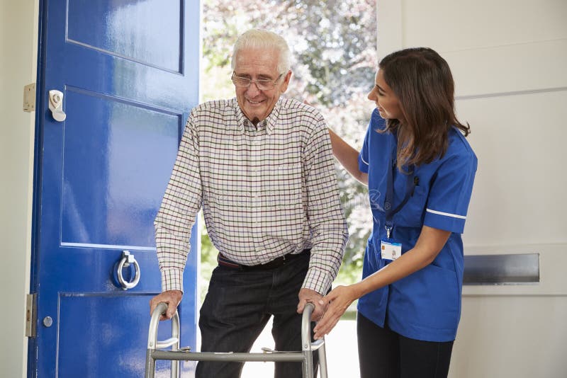 Nurse helps senior man using walking frame at home, close up