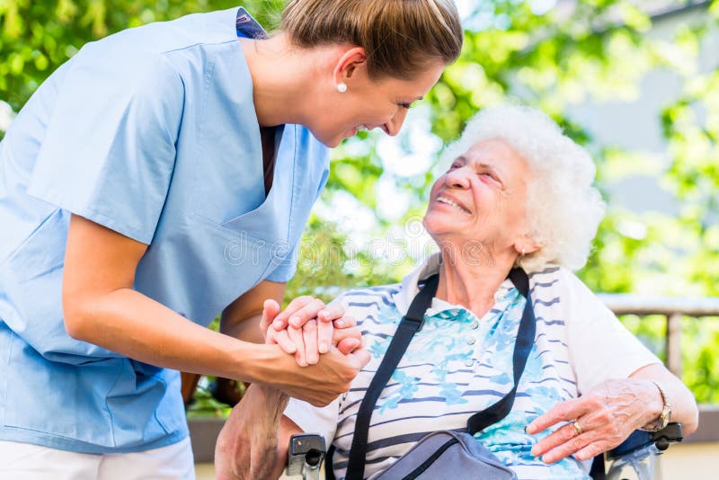 Nurse holding hand of senior women in pension home