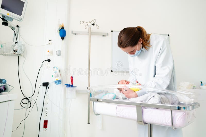 Nurse in ICU examining premature born child