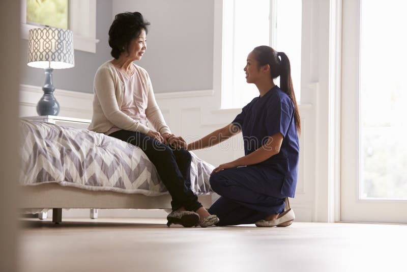 Nurse Making Home Visit To Senior Woman