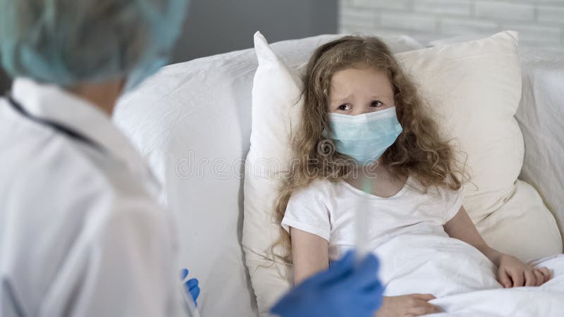 Nurse preparing to make injection to scared girl, wearing face mask, infection stock image Nurse preparing to make injection to scared girl, wearing face mask, infection stock image