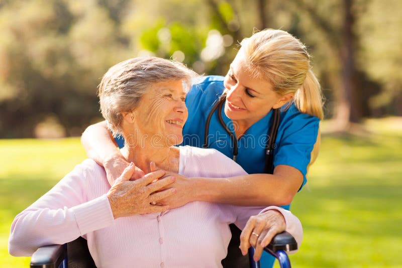 Caring nurse with senior patient outdoors. Caring nurse with senior patient outdoors