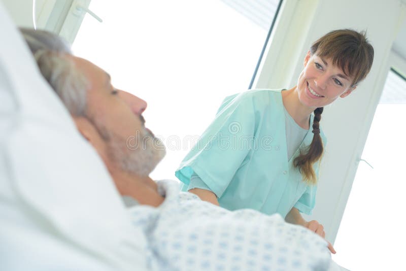 Nurse smiling at male patient royalty free stock photography Nurse smiling at male patient royalty free stock photography
