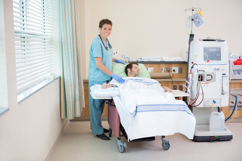 Nurse Standing By Patient Receiving Dialysis In