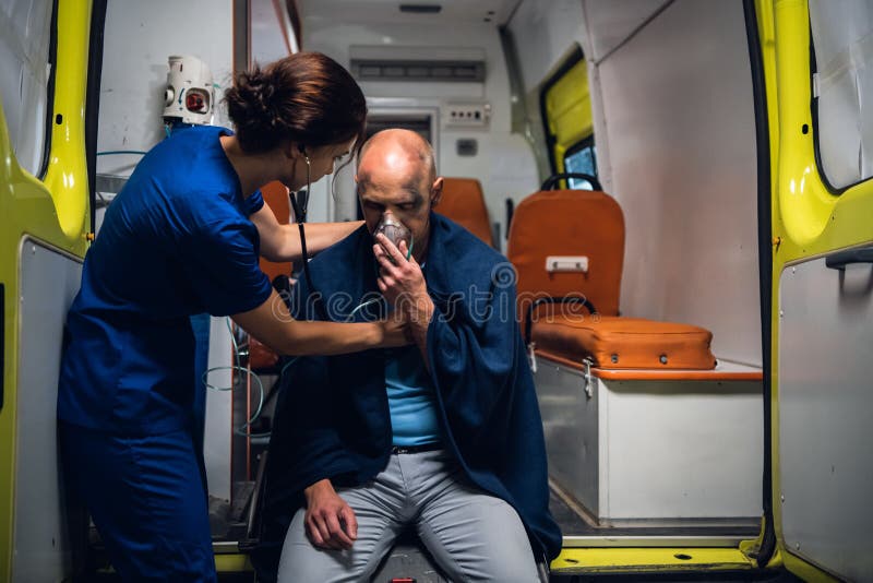 Nurse With Stethoscope And Man Sits In Oxygen Mask In Blanket In The