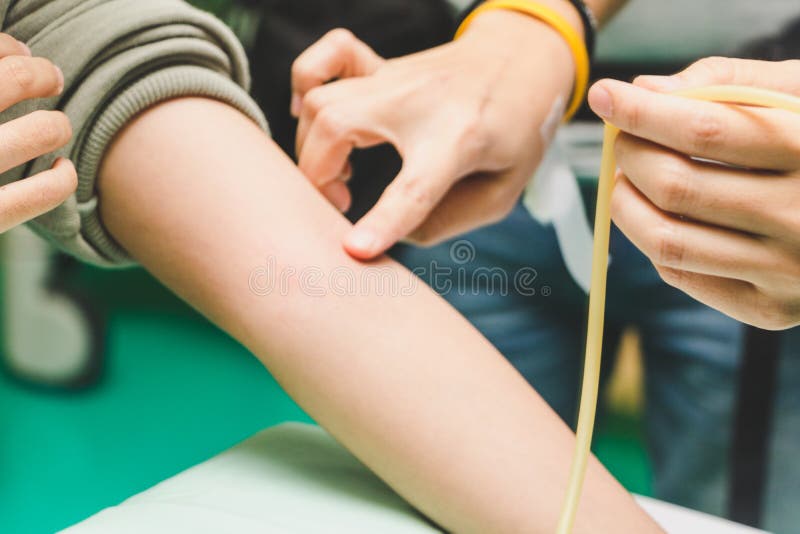 The nurse takes the patient`s blood with a syringe. Nurse takes the patient`s blood with a syringe. She had a blood clot in her arm with a cotton swab off the royalty free stock photo The nurse takes the patient`s blood with a syringe. Nurse takes the patient`s blood with a syringe. She had a blood clot in her arm with a cotton swab off the royalty free stock photo