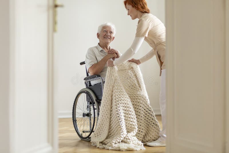 Nurse taking care of happy elderly man in a wheelchair in his ho royalty free stock photo Nurse taking care of happy elderly man in a wheelchair in his ho royalty free stock photo