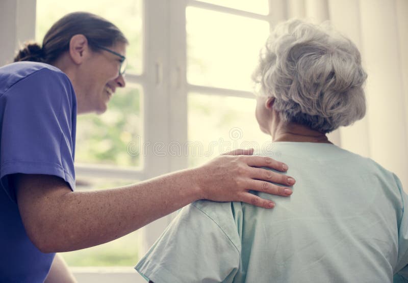 Nurse taking care of an old woman stock image