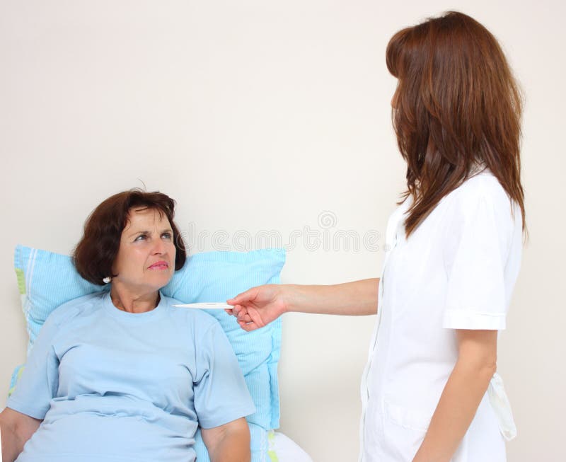 A nurse with thermometer and a patient