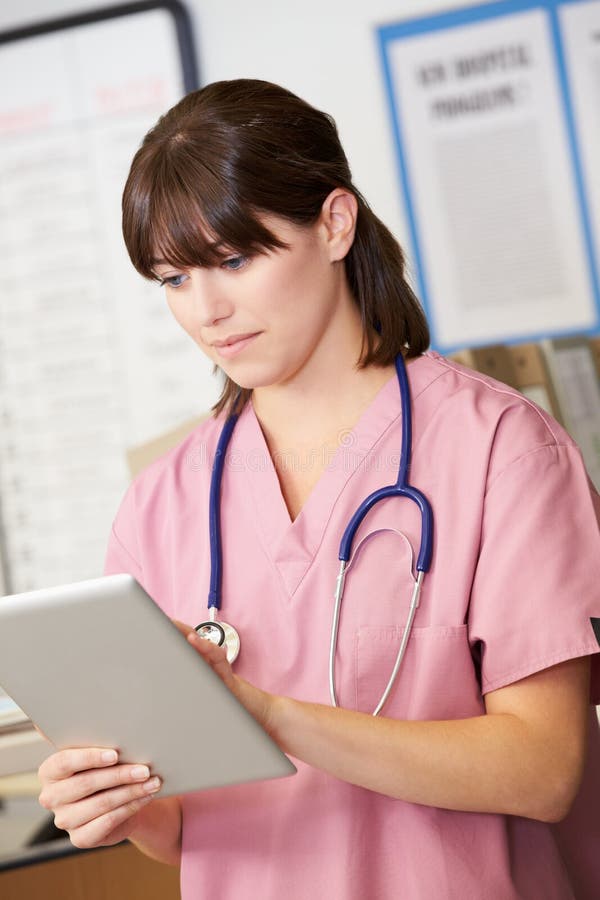 Nurse Using Digital Tablet At Nurses Station stock images Nurse Using Digital Tablet At Nurses Station stock images
