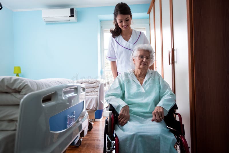 Nursing home, nurse goes outside with old woman at wheelchair royalty free stock images Nursing home, nurse goes outside with old woman at wheelchair royalty free stock images