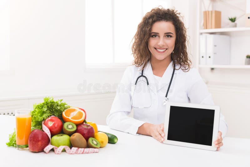 Nutricionista do doutor que guarda a tabuleta digital vazia, modelo imagem de stock royalty free Nutricionista do doutor que guarda a tabuleta digital vazia, modelo imagem de stock royalty free