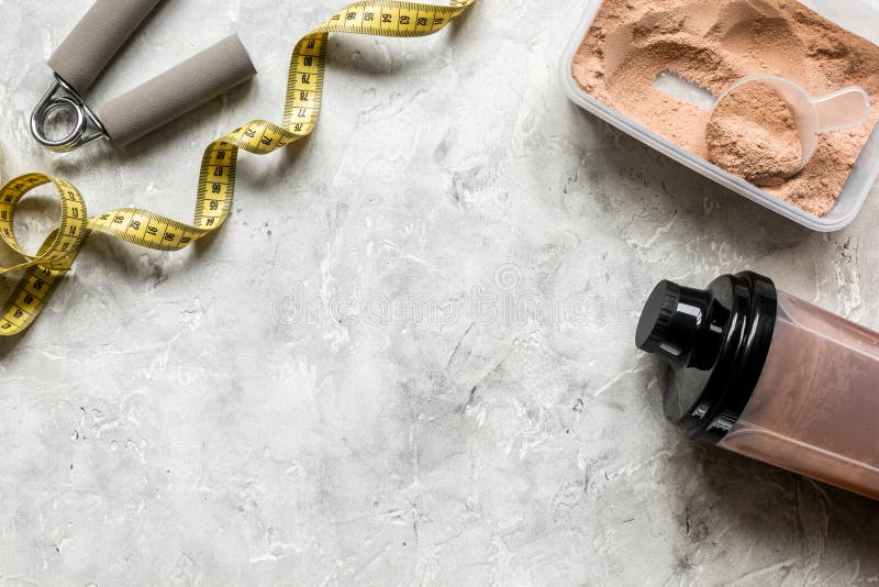 Nutrition pour la séance d'entraînement avec la poudre de cocktail de protéine, la bande de mesure et les barres sur la maquette images stock Nutrition pour la séance d'entraînement avec la poudre de cocktail de protéine, la bande de mesure et les barres sur la maquette images stock