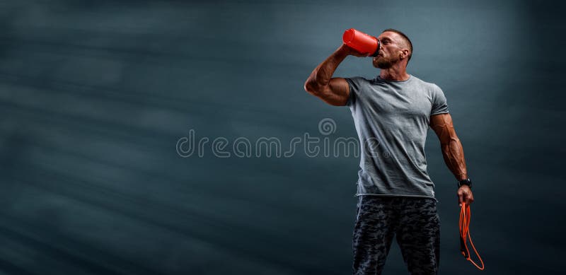 Nutritional Supplement. Muscular Men Drinks Protein, Energy Drink After Workout. Studio shot